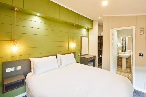 1 dormitorio con cama blanca y baño en Host & Stay - Eller Beck, The Cabin In The Woods, en Egton