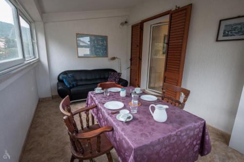 a dining room table with a purple table cloth on it at Villa Goga in Martinšćica