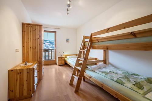 a bedroom with two bunk beds and a desk at Urlaub auf dem Bauernhof Hallerhof in Villandro