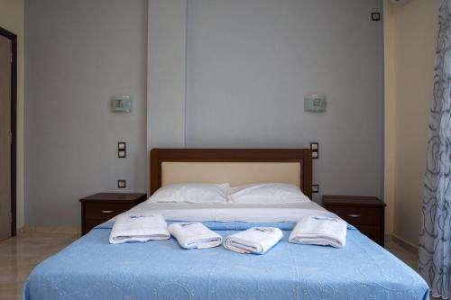 a bed with two towels on top of it at Blue Waves Houses in Plomarion