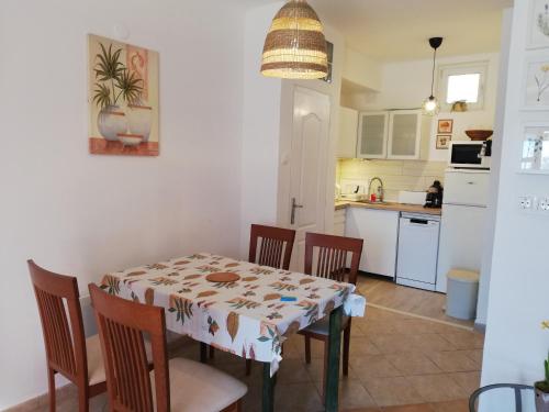 cocina y comedor con mesa y sillas en Udvari-ház, en Balatonudvari