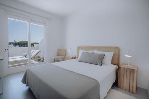 a bedroom with a white bed and a large window at Casa Balaia 70 in Albufeira