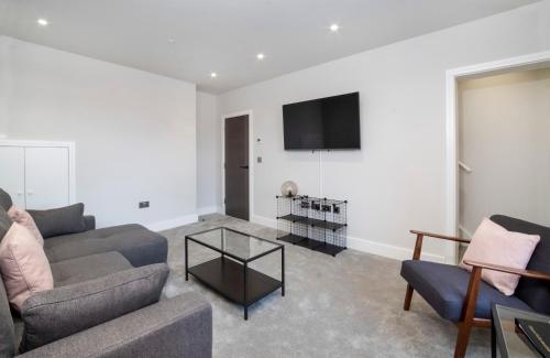 a living room with a couch and a tv on a wall at The Old Hotel in York