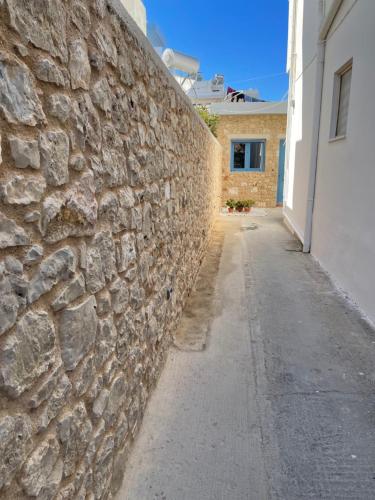 a stone wall next to a sidewalk next to a building at Kos Center Katerina in Kos Town
