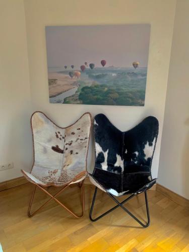 two chairs sitting in a room with a painting at la Tour d'Héloïse - 10' de Bruxelles in La Hulpe
