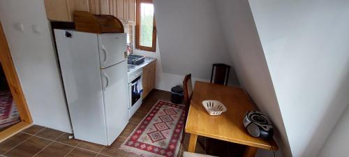 a small kitchen with a white refrigerator and a table at Vila Tri Srca in Beserovina