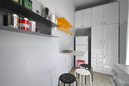 a kitchen with two stools and a table and cabinets at Nice Apartment Near City Center in Athens