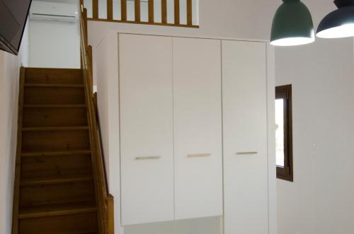 a room with a staircase and a white cabinet at Villa Dimitris in Palekastron