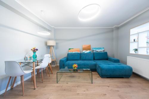 a living room with a blue couch and a table at Central Chic Otopeni in Otopeni