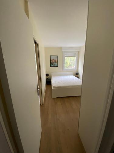 a small bedroom with a bed and a window at Appart 6 pers au Bord de la Mer in Le Pouliguen