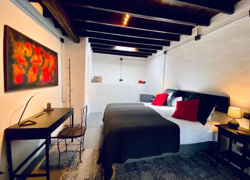 a bedroom with a bed with red pillows and a desk at Finca Curbelo in Uga