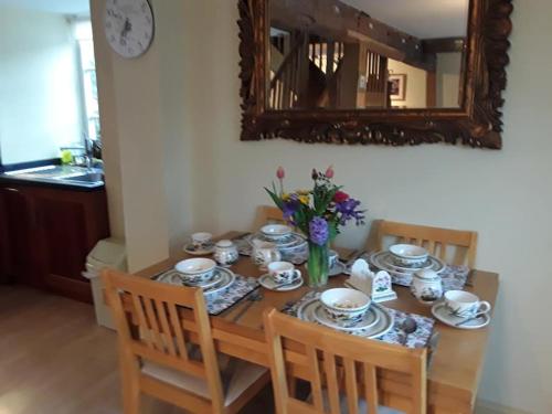 a dining room table with plates and cups and a mirror at THE RETREAT in Hereford