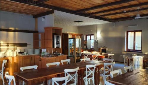 una cocina con una gran mesa de madera y sillas blancas. en Hotel Alla Torre en Garda