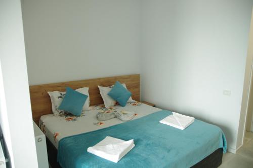 een slaapkamer met een bed met blauwe en witte kussens bij Studio David Eforie Nord in Eforie Nord