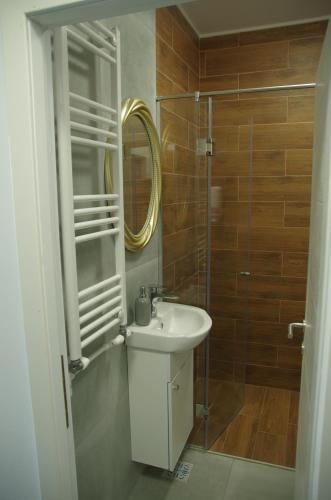 ein Badezimmer mit Waschbecken und Dusche mit Spiegel in der Unterkunft Studio David Eforie Nord in Eforie Nord