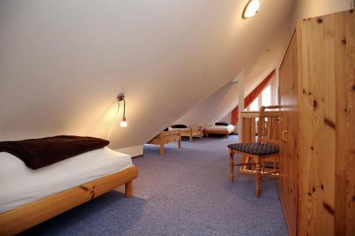 - une chambre mansardée avec un lit et des chaises dans l'établissement Villa Augusta Wohnung 13, à Boltenhagen