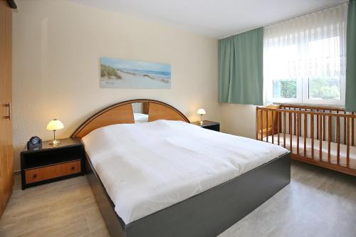 1 dormitorio con 1 cama grande y 1 cuna en Am Mariannenweg Wohnung 07 en Boltenhagen