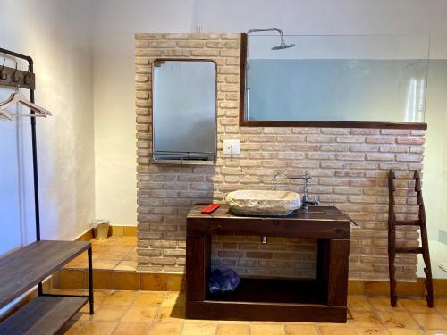 ein Badezimmer mit einem Waschbecken und einer Ziegelwand in der Unterkunft Origens II - Ideal para parejas in Perelló