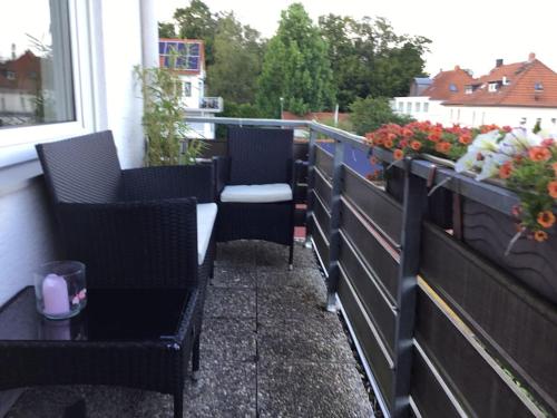 einen Balkon mit Stühlen, einem Tisch und Blumen in der Unterkunft Elegant and Quiet in Wiesbaden