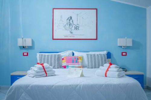 a blue room with a bed with towels on it at Victoria Resort in Ascea