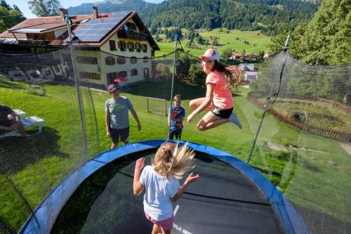 a group of children jumping over a trampoline at Gästehaus Schlegel in Gunzesried