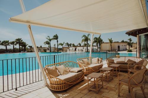 patio con sedie e piscina di GINKÒ Music Hotel a Lequile