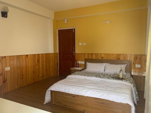 a bedroom with a large bed with wooden walls at NOLINA BOUTIQUE HOMESTAY in Namchi