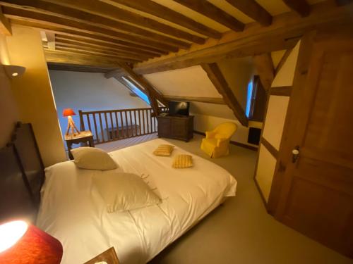 a bedroom with a white bed in a attic at Le Hameau de Barboron in Savigny-lès-Beaune