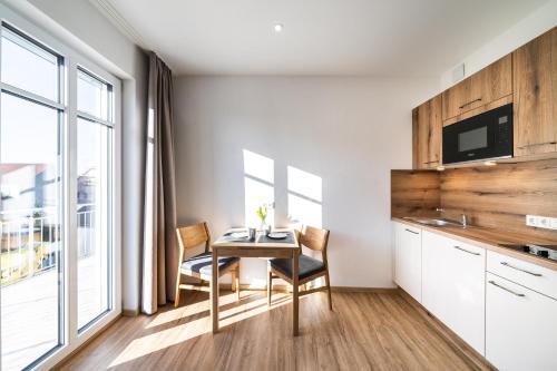 a kitchen with a table and chairs in a room at Kaneder Hof - Self Check-in in Inchenhofen