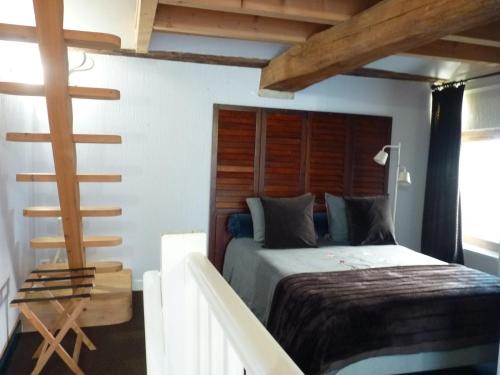 una camera da letto con un letto con testiera in legno di La petite maison CARRÉ a Talant