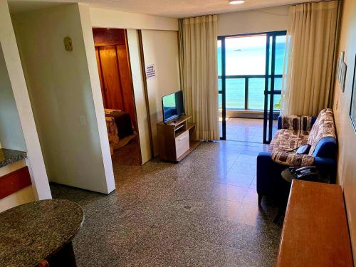 a living room with a couch and a television at Avenida Beira Mar, The Best view! in Fortaleza