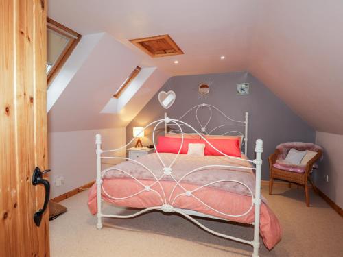 a bedroom with a white bed in a attic at Bogindour Cottage in Muir of Ord
