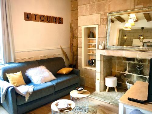 uma sala de estar com um sofá azul e uma lareira em Vieux Tours, Charmant T2 40m2, 4 pers, lumineux em Tours