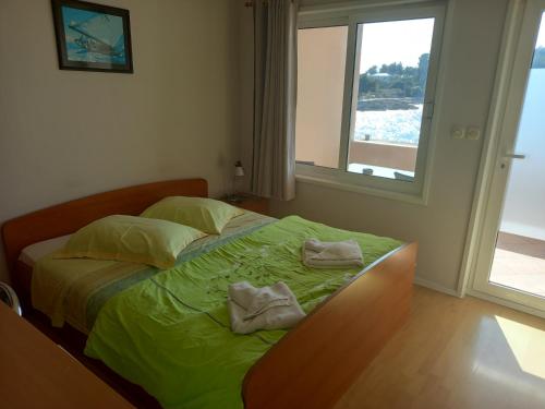 
a bedroom with a bed and a window at Riva1 Apartments and Rooms in Prizba
