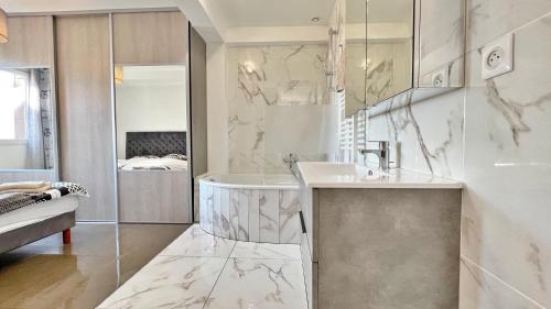 une salle de bain blanche avec un lavabo et un miroir dans l'établissement L'Avenir du Ray, à Nice