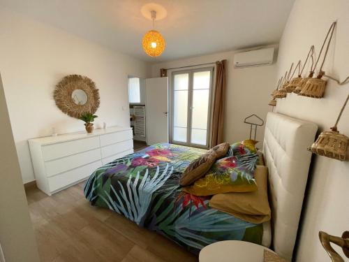 a bedroom with a bed and a dresser and a window at Les jardins de Funtanone T3 in Vignale