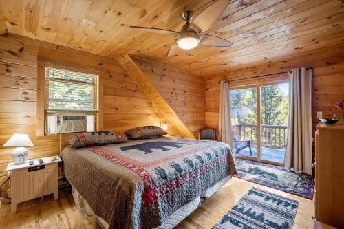 a bedroom with a bed in a log cabin at Log Home Retreat at Lake Winnipesaukee! in Meredith