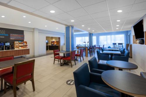 a waiting room with tables and chairs and tablesktop at Holiday Inn Express Hotel & Suites Woodhaven, an IHG Hotel in Woodhaven