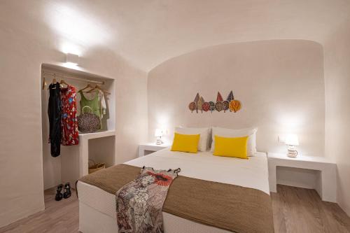 a bedroom with a bed with yellow pillows at White Orchid Cave House & Studio in Pirgos