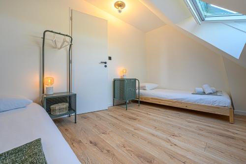 - une chambre mansardée avec 2 lits et une fenêtre dans l'établissement LA LANDE TREVRAS - Petite Maison de charme, à Baden