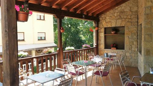 un patio con mesas y sillas en el balcón en Hotel Rural Cabrales, en Carreña