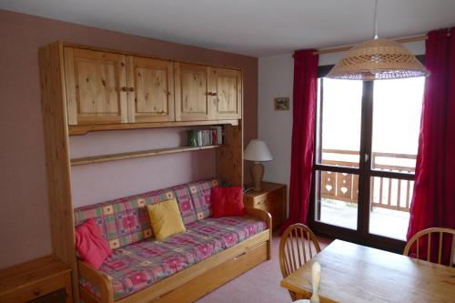 uma sala de estar com um sofá e uma mesa em Studio coin montagne à Auris en Oisans avec vue magnifique em Auris