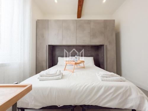 sypialnia z dużym białym łóżkiem i drewnianym stołem w obiekcie Gold River House w mieście Ferrara