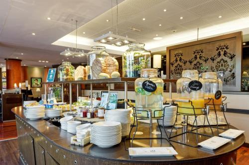 un restaurant avec des assiettes et des bocaux en verre sur un comptoir dans l'établissement Golden Tulip Paris CDG Airport – Villepinte, à Roissy-en-France
