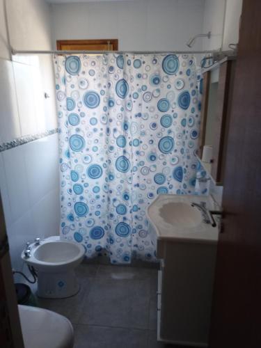 a bathroom with a toilet and a shower curtain at LOS CEDROS in Junín de los Andes