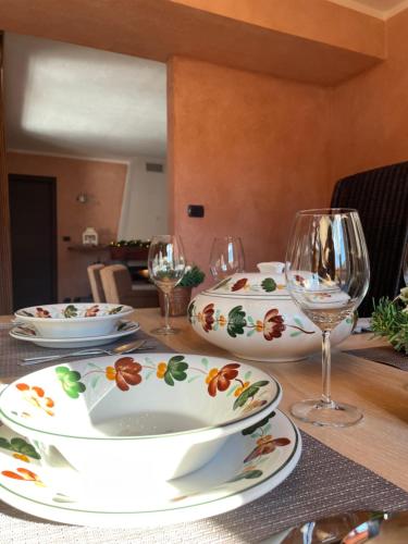 a table with plates and wine glasses on it at Suite - La Casa del Maestro in Pragelato