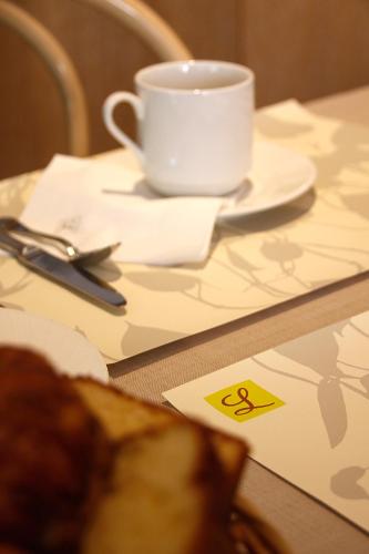 a table with a coffee cup and a napkin at Chez Terrassier - Logis Hôtels - Hotel et Restaurant in Vaissac