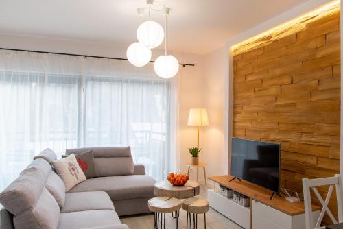 ein Wohnzimmer mit einem Sofa und einem Flachbild-TV in der Unterkunft Szczyrkowskie SKI & FUN 8 z balkonem in Szczyrk