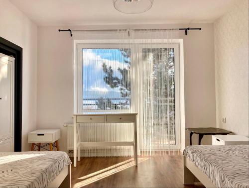 a bedroom with two beds and a window with a view at More Home Cycling in Męcina