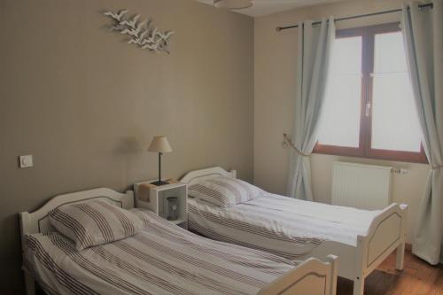 2 camas individuales en una habitación con ventana en La Belle Etap', gîte classé 3 étoiles en Étaples